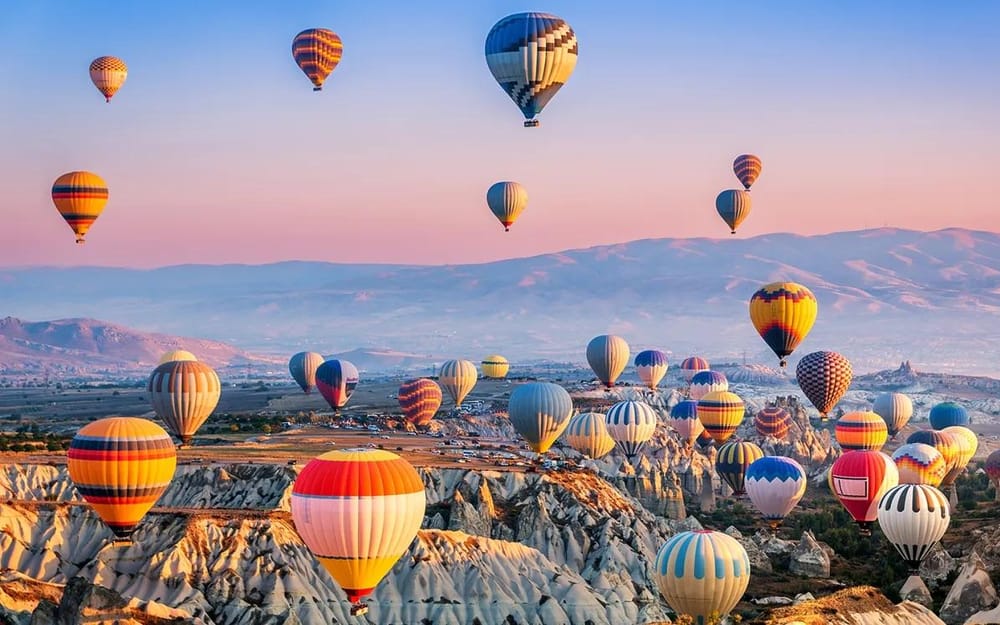 Colourful hot air balloons lifting off above Cappadocia