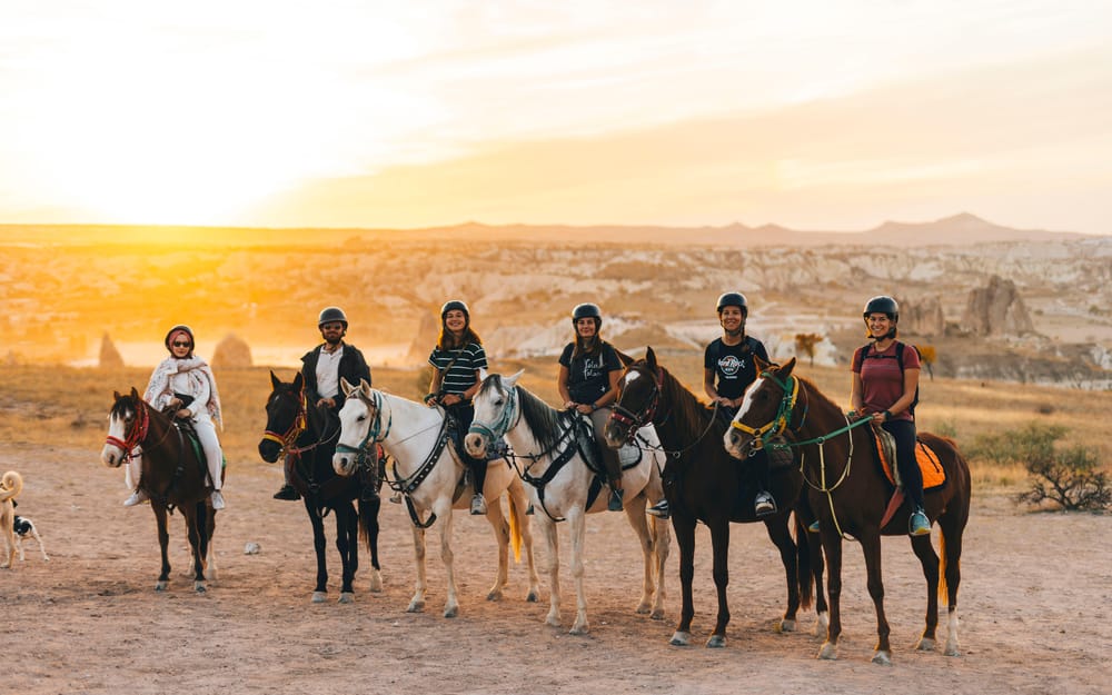 A group of riders on horseback in Cappadocia’s open landscape