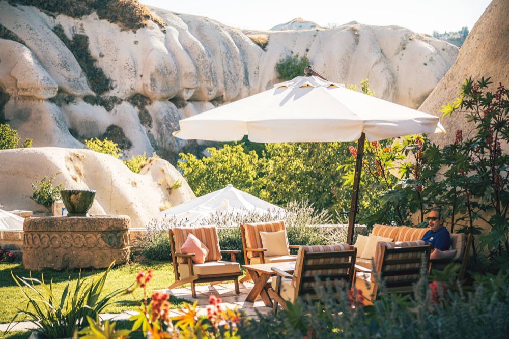 Garden seating beneath an umbrella at Aza Cave Hotel